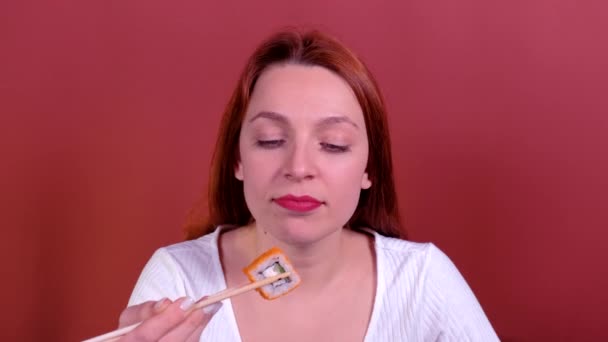 Retrato Pelirroja Mujer joven comiendo sushi con palillos . — Vídeos de Stock