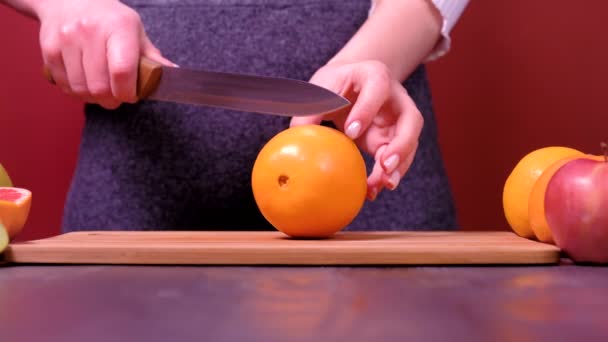 Kvinnans händer skära färska orange på kök — Stockvideo