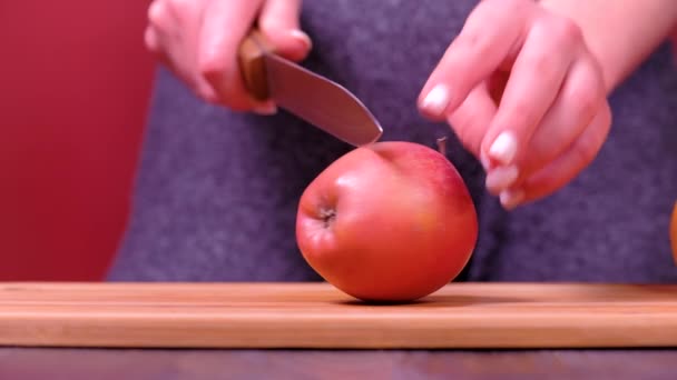 Vrouwen handen snijden verse appel in de keuken — Stockvideo