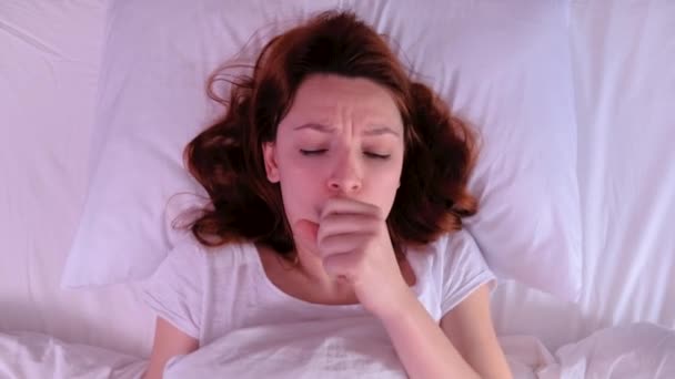 Vue de dessus Jeune femme aux cheveux roux tousse le matin au lit et est malade . — Video