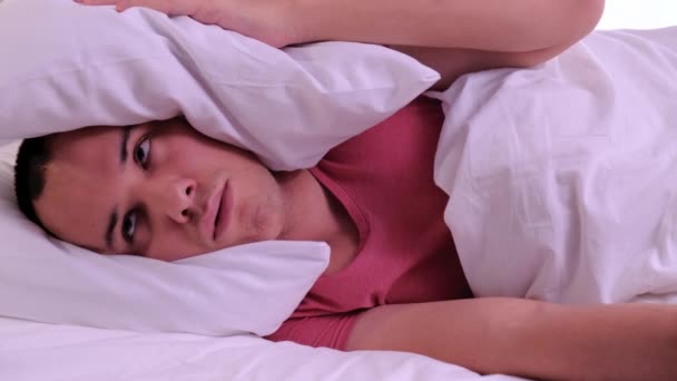 Homme essayant de dormir ennuyé par de mauvais voisins bruyants chambre couvrant les oreilles avec oreiller, se réveiller couché dans le lit souffrent d'insomnie — Video