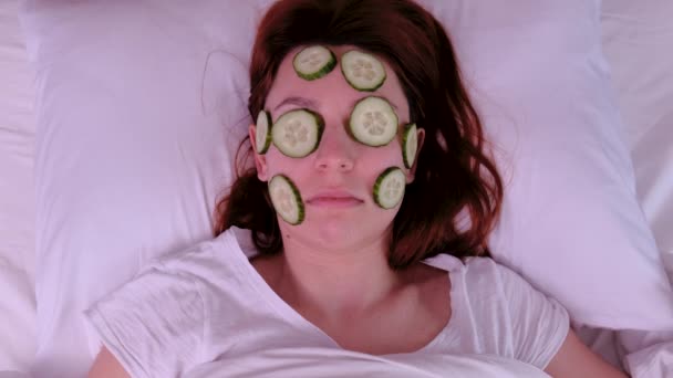 Young woman with cucumber slices on the face in a spa saloon — Stock Video