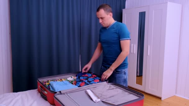 Un hombre prepara una maleta para viajar . — Vídeo de stock