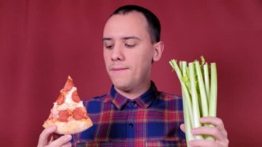 Sağlıklı ya da sağlıksız yiyecekleri seçen bir adam. Diyet kilo kaybı sağlık hizmeti konsepti. Pizza ve Serdula arasında seçim yapan bir adam, sağlıklı ya da hızlı, abur cubur. Yararlı ya da zararlı bir yaşam tarzı.