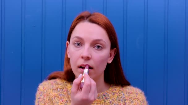 Ung modell sätter på lite makeup, med läppstift för att färga helläppar. Kosmetiskt begrepp. — Stockvideo