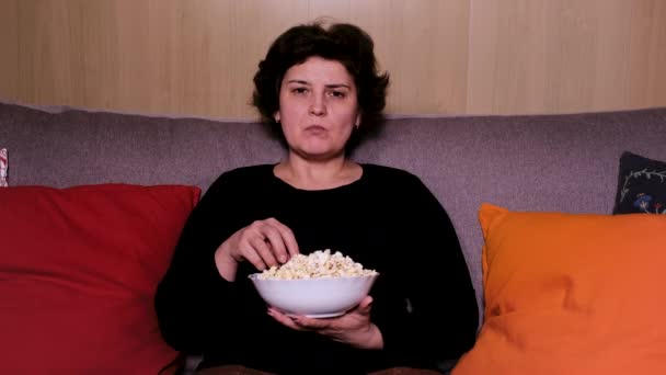 Woman watching a movie with eating popcorn — Stock Video