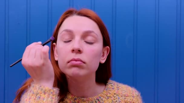 La femme se maquille. Jeune femme fait rougir sur le visage à l'aide d'une brosse de maquillage. Concept cosmétique . — Video