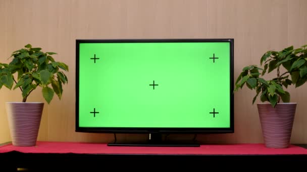 TV com tela verde composta. TV ou televisão - tela verde - quarto - na mesa. TV LCD com faixa de tela verde na moderna sala de estar — Vídeo de Stock