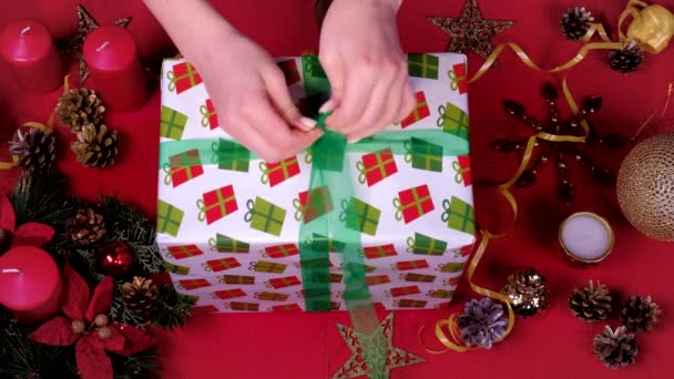 Top view Close up női kéz és díszíteni karácsonyi ajándék doboz. Csomagolás és kicsomagolás. Az ünnepek és az új év koncepciója. téli ünnepség. — Stock videók