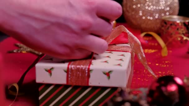 Közelíts női kéz és díszíteni karácsonyi ajándék doboz. Csomagolás és kicsomagolás. Az ünnepek és az új év koncepciója. téli ünnepség. — Stock videók