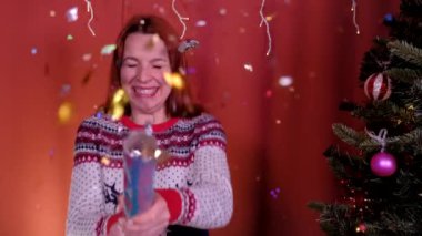 Konfeti patlatan bir kadın. Tatil, Noel ve Yeni Yıl kavramı.