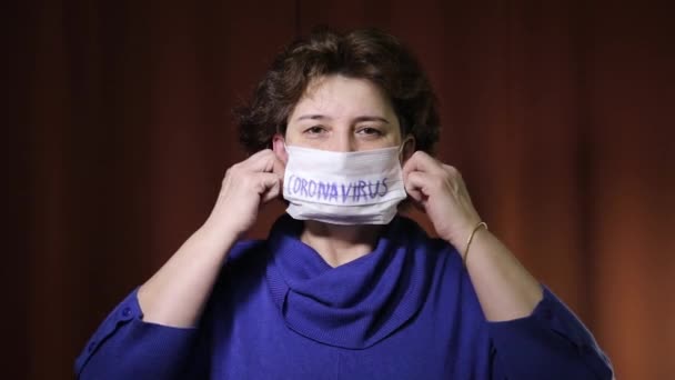 Blanke vrouw in medisch proteïef masker inscriptie 2019-nCov. Coronavirusuitbraak in Europa. Paniek, angst voor pandemisch virus covid-19 concept. — Stockvideo