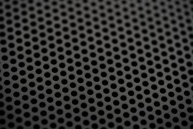 Yuvarlak deliklerin delindiği metalik bir zemin. Yuvarlak delikli siyah metal desenli. Sanayi geçmişi.