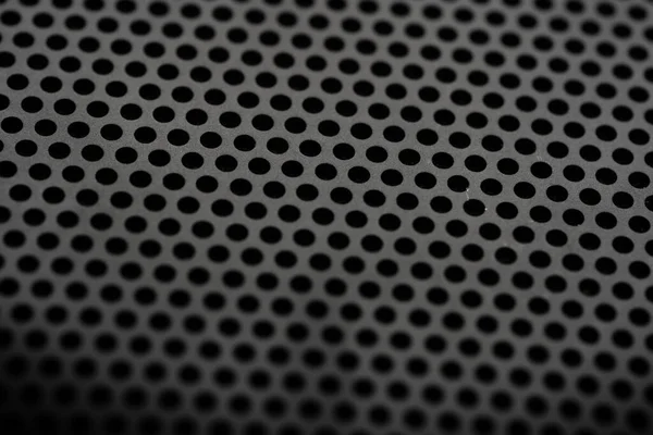 Metallic background with perforation of round holes. Black metal texture with round holes. Industrial background.