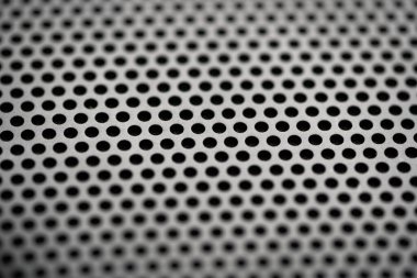 Yuvarlak deliklerin delindiği metalik bir zemin. Yuvarlak delikli siyah metal desenli. Sanayi geçmişi.
