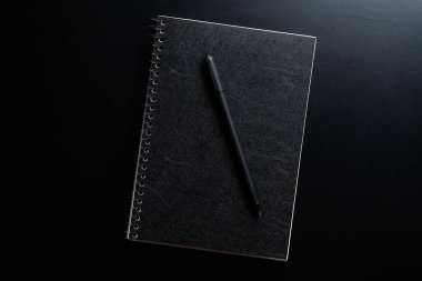 Siyah biçim seti: Siyah arkaplanda not defteri ve kalem.