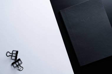 Siyah biçim seti: Siyah arkaplan üzerinde not defteri, kalem ve kağıt ataçları