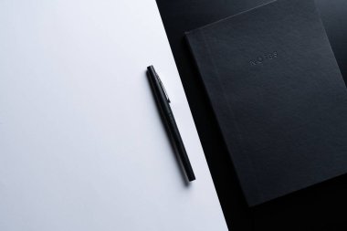 Siyah biçim seti: Siyah arkaplanda not defteri ve kalem.