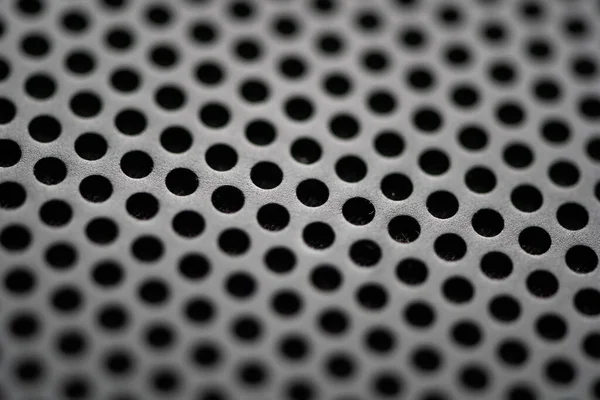 Metallic background with perforation of round holes. Black metal texture with round holes. Industrial background.