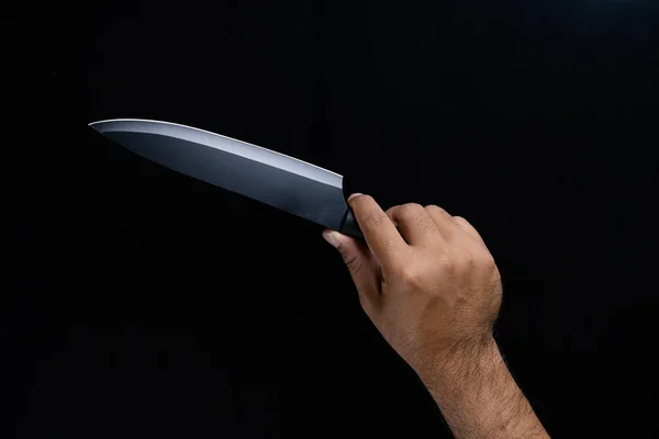 黒の背景に隔離された黒いシェフのナイフを持っている男の手 — ストック写真