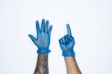 Mavi lastik eldivenli bir adam eli ve hareketleri beyaz arka planda izole edilmiş altı parmak izi gösteriyor..