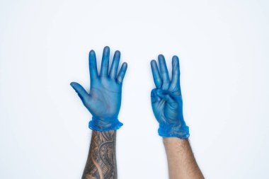Mavi lastik eldivenli bir adam eli ve hareketleri beyaz arka planda 8 parmak izi gösteriyor..