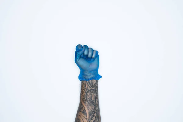 A man hand and gestures in Blue rubber glove shows fist scat sign isolated on white background.