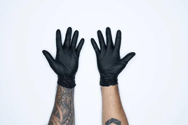 A man hand and gestures in Black rubber glove shows ten sign isolated on white background.