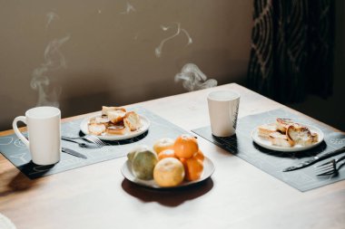 İki kişi için kahvaltı - kahve, çay, ekmek ve meyve.