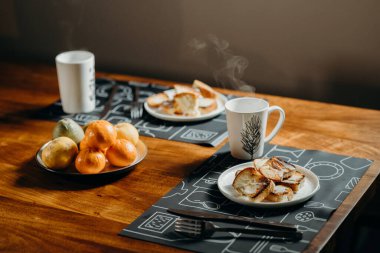 İki kişi için kahvaltı - kahve, çay, ekmek ve meyve.