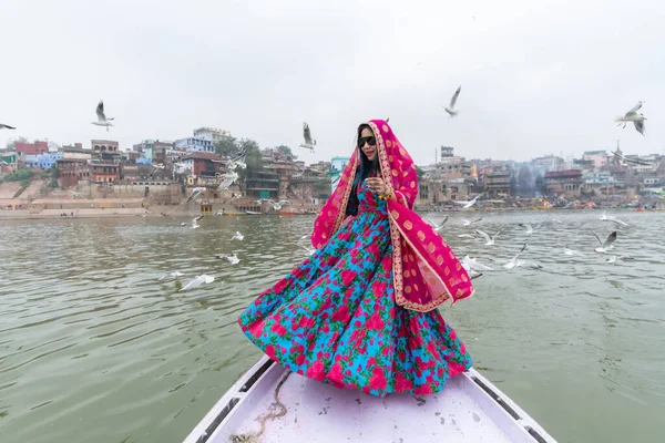 Beautiful south east asian girl in traditional Indian sari/saree on boat at Varanasi, India.