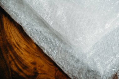 Müşteri için teslimat kutusunun ayarlanması, çevrimiçi satışlar, ahşap masada plastik baloncuklar. Online alışveriş kavramları.