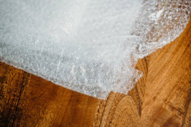 Müşteri için teslimat kutusunun ayarlanması, çevrimiçi satışlar, ahşap masada plastik baloncuklar. Online alışveriş kavramları.