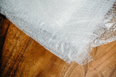 Müşteri için teslimat kutusunun ayarlanması, çevrimiçi satışlar, ahşap masada plastik baloncuklar. Online alışveriş kavramları.