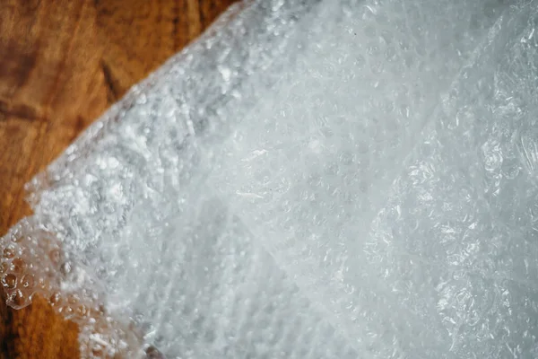 Müşteri için teslimat kutusunun ayarlanması, çevrimiçi satışlar, ahşap masada plastik baloncuklar. Online alışveriş kavramları.