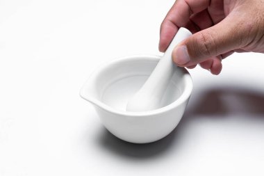 Havan öğütücü ve beyaz arka planda izole edilmiş otlarla dolu bir adam eli. Kopyalama alanı.