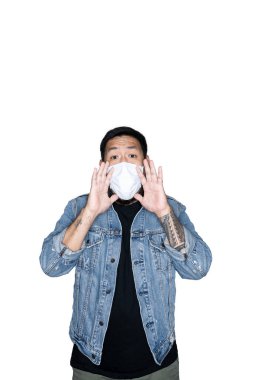 Tıbbi maskeli, kot giymiş sakallı Asyalı erkek işçi beyaz arka planda iki elle bağırıyor. Protesto, dikkat, istek kavramı. Metin veya kopyalama alanı için yer. Kesme yolu.