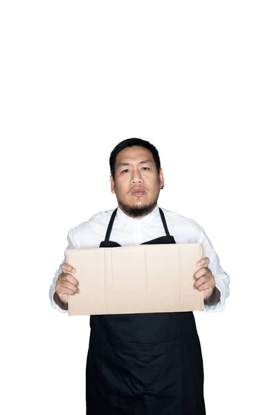 Bearded asian men waiter, chef dressed in black apron is holding cardboard in white background.The concept of protest, attention, request. Place for text or copy space.  Clipping path.