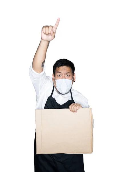 Bearded asian men waiter, chef dressed in black apron with medical mask is holding cardboard and showing point finger in white background.The concept of protest, attention, request. Place for text or copy space.  Clipping path.