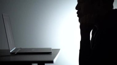 Laptop 'ta çalışan Asyalı siluet adam. Beared Man, Notebook 'ta evden çalışıyor. Serbest çalışan blogcu adam dizüstü bilgisayarla evde çalışıyor. Bakan ve düşünen bir adam.