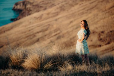 Güzel Asyalı kadın, Yeni Zelanda 'da gün batımını seyrediyor. Christchurch' ün varoşlarında kırsal kesimde..