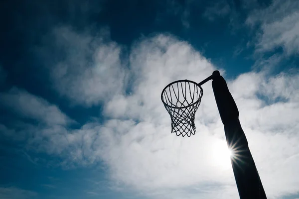 Netball gol çemberi ve net mavi gökyüzü ve bulutlara karşı Hagley Park, Christchurch, Yeni Zelanda.