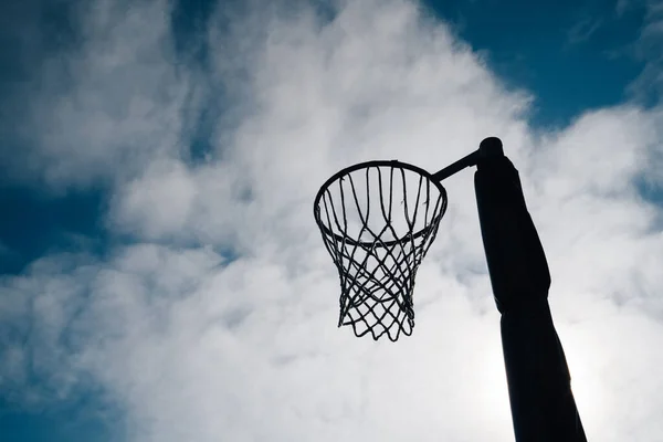 Netball gol çemberi ve net mavi gökyüzü ve bulutlara karşı Hagley Park, Christchurch, Yeni Zelanda.