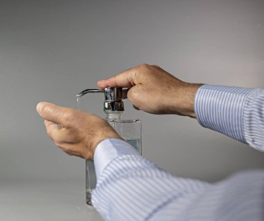 Adam ellerini cam sabun tabaklarında yıkıyor.