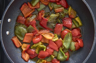 Küçük parçalar halinde kızarmış kırmızı ve yeşil biber.