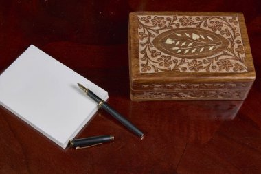 Not defteri, kalem ve tahta kutu.