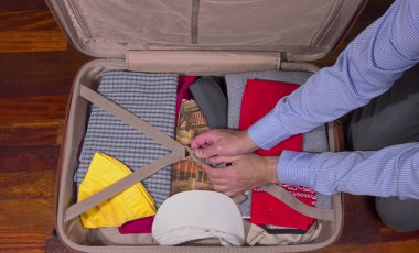 Seyahat için giysi ve eşya dolu bavul