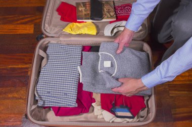 Seyahat için giysi ve eşya dolu bavul