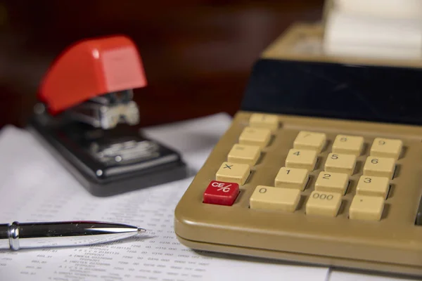 Şirket muhasebe raporu, hesap makinesi ve zımba.