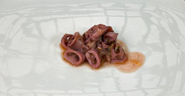 Sos ve soğanlı kalamar tabağı. Bu aşırı büyük olmayan tüm mürekkep balıklarına verilen isimdir..